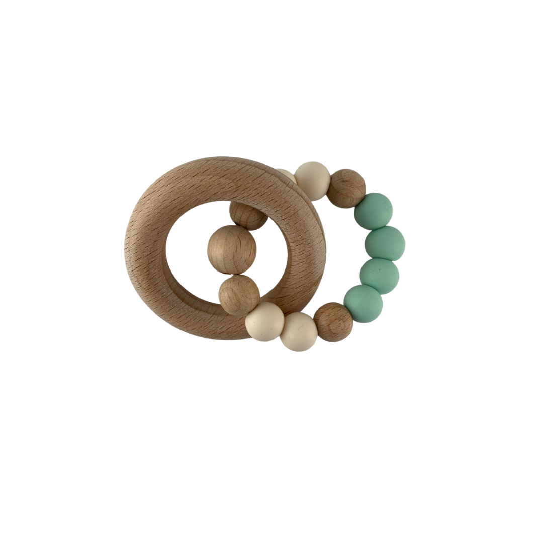 Hochet de dentition rond fait de billes de bois et silicone de couleur vert menthe avec anneau de bois.