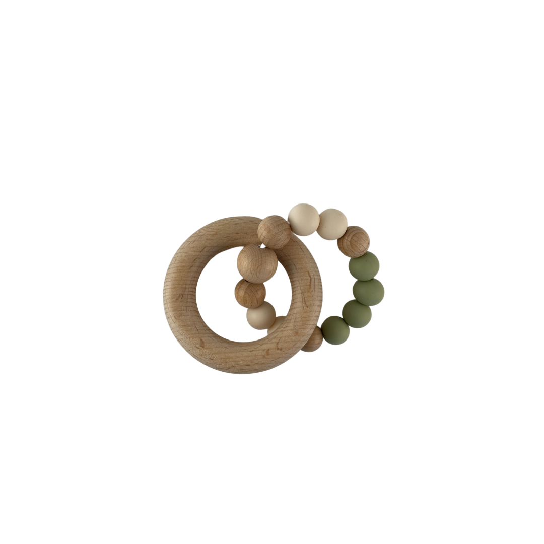 Hochet de dentition rond fait de billes de bois et silicone de couleur vert sauge avec anneau de bois.